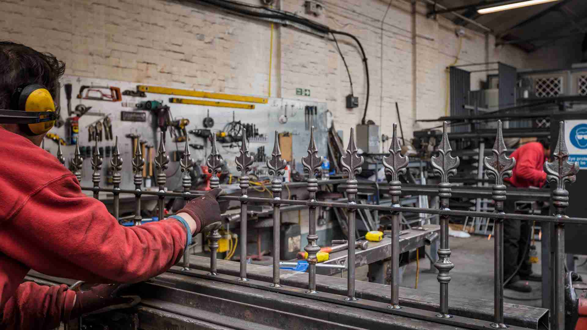 Bespoke black wrought iron wall top railings being manufactured in a London workshop for a residential property.